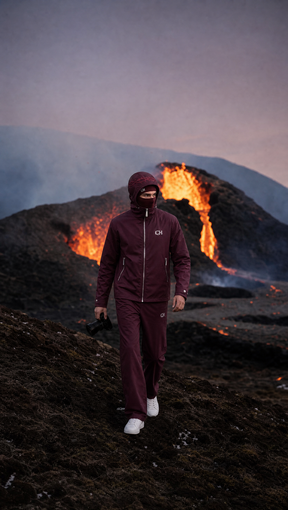 The burgundy LUKAS Rain Shell beside a volcanic crater.